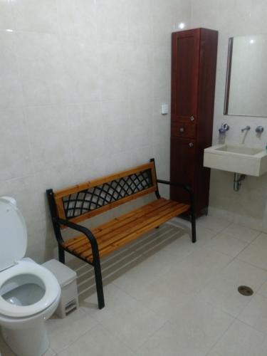 a bathroom with a bench and a toilet and a sink at Namaste in Tel Aviv