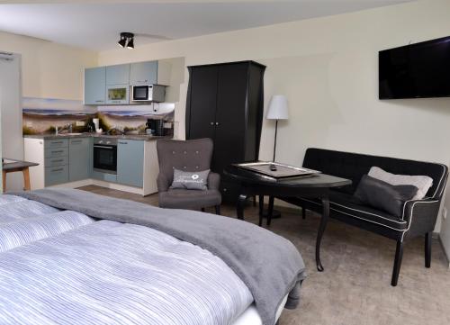 ein Schlafzimmer mit einem Bett und einem Tisch sowie eine Küche in der Unterkunft Aparthotel-Stadtallendorf in Stadtallendorf