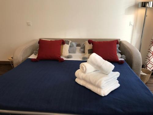 a bed with towels on it with a couch at Chouette Massena in Nice