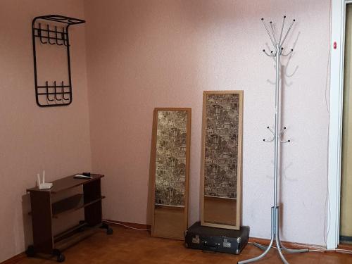 スタールイ・オスコルにあるТрехкомнатная квартираの壁に鏡が2つあり、テーブルが備わるお部屋