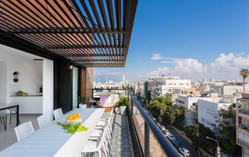 a balcony with a table and a view of a city at Mr. Ben Yehuda - By TLV2GO in Tel Aviv