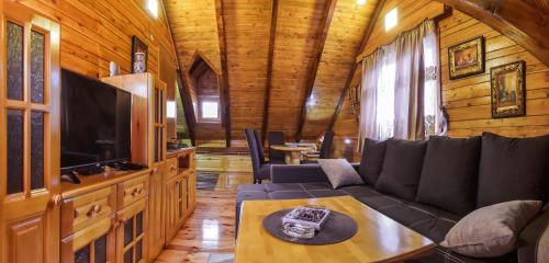 a living room with a couch and a tv at Lumber Apartments Kolašin in Kolašin