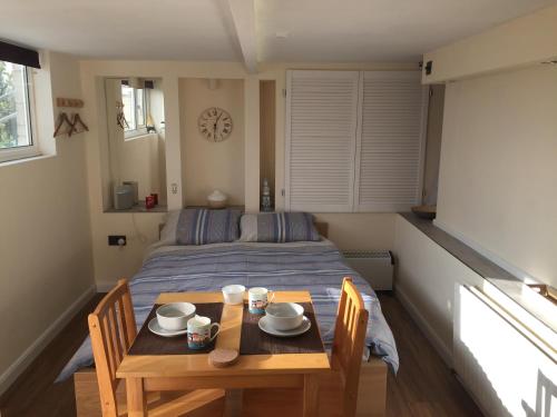 a small room with a table and a bed at Self-contained small apt. Weymouth in Weymouth