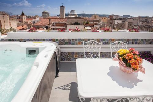 a balcony with a hot tub and a vase of flowers at "Bea's Terrace" - Private Jacuzzi and panoramic rooftop in the City Centre in Cagliari