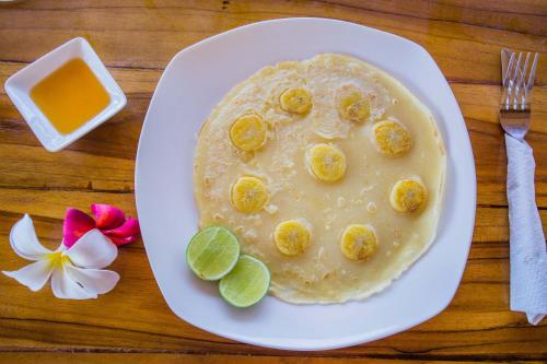 a plate of pancakes with a face made out of bananas at Sunset Coin Lembongan in Nusa Lembongan