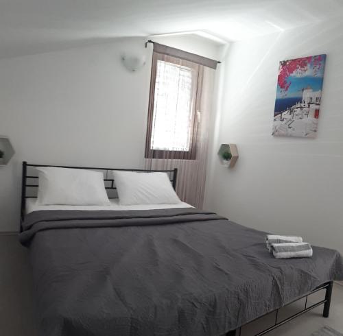 a bed in a white room with a window at Apartment Aquamarine in Vir