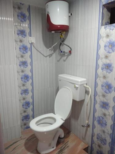a bathroom with a toilet with a water tank at Babusona Homestay in Jaldapara in Mādāri Hāt