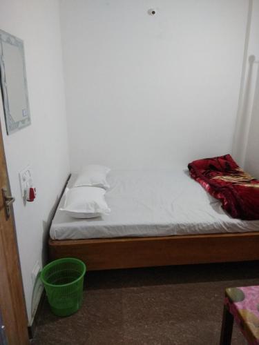 a bed in a room with a green basket at Babusona Homestay in Jaldapara in Mādāri Hāt