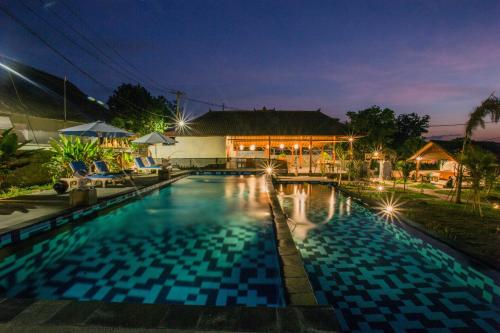 a swimming pool in front of a house at night at D'Coin Lembongan in Nusa Lembongan