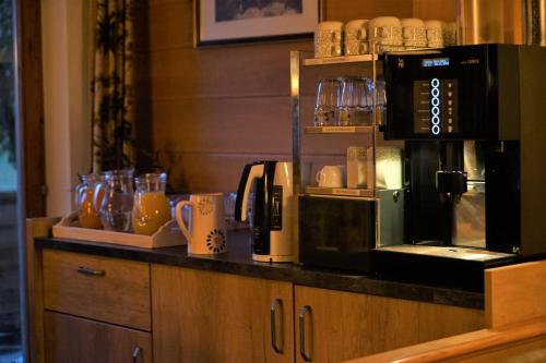 een aanrecht met een koffiezetapparaat en kopjes erop bij Villa Cornelia in Sölden