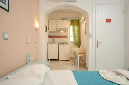 Habitación pequeña con cama y cocina en Sunday Studios, en Agia Anna de Naxos