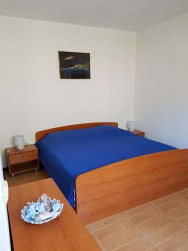 1 dormitorio con cama y mesa de madera en Robinson Crusoe holiday house, en Zastražišće