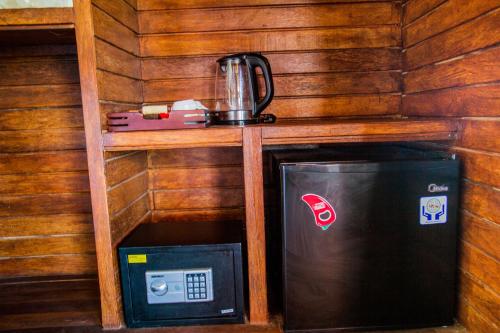 a small kitchen with a microwave and a coffee maker at D'Coin Lembongan in Nusa Lembongan