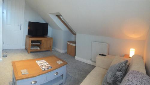 a living room with a couch and a tv at Rosenn Teyr in St. Agnes