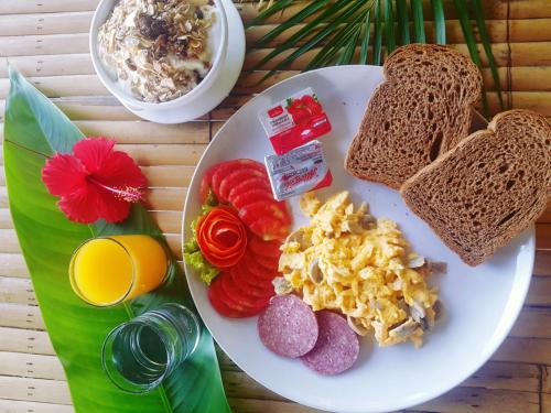 a plate of breakfast food with toast and fruit at Koh Jum Coral Bay Resort in Ko Jum