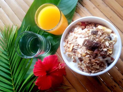 a bowl of cereal and a glass of orange juice at Koh Jum Coral Bay Resort in Ko Jum