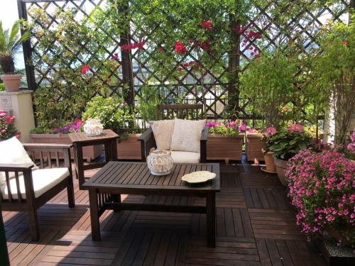 a patio with a table and chairs and flowers at Hepburn Holiday Home in Salerno