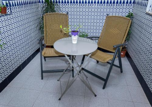 una mesa blanca y 2 sillas en el patio en Apartamento Centro PARKING GRATIS, en Córdoba