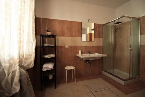La salle de bains est pourvue d'un lavabo, d'une douche et d'un tabouret. dans l'établissement Radices Bed & Breakfast, à Campobasso