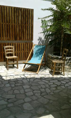 a wooden chair and a blue chair and a table and two chairs at Christiana's stone studios in Pano Lefkara