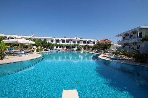 uma piscina com água azul num resort em Garden Hotel em Pastida