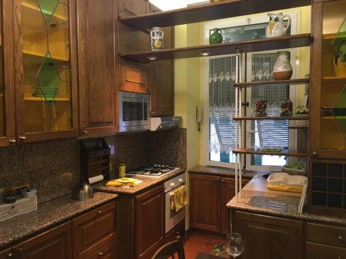 a kitchen with wooden cabinets and a stove top oven at Finestra su Genova - free parking in Genoa
