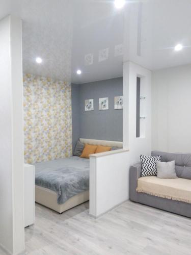 a bedroom with two beds and a couch at Студия на Соборной 58 in Khmelʼnytsʼkyy