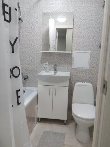 een badkamer met een toilet, een wastafel en een spiegel bij Студия на Соборной 58 in Chmelnytsky