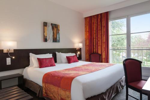 um quarto de hotel com uma cama grande e uma janela em La Berteliere, The Originals Relais (Qualys-Hotel) em Saint-Martin-du-Vivier