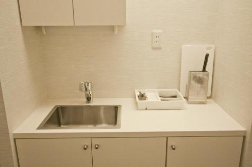 um balcão de cozinha com um lavatório e um suporte para guardanapos em Place 11 Building / Vacation STAY 2139 em Sapporo