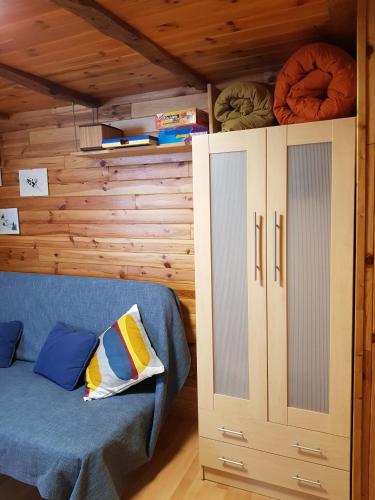 a room with a blue couch and a cabinet at Estudio en Edificio Presidente in Sierra Nevada