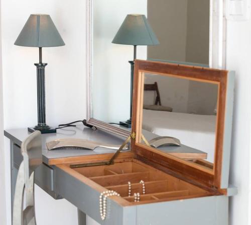 a mirror sitting on top of a desk with a lamp at Home47 in Salerno