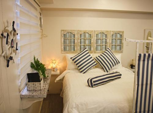 a bedroom with a bed with striped pillows on it at Amaia Steps Capitol Central in Bacolod