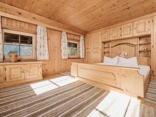 a bedroom with a bed in a wooden room at Ferienhaus Hanserhof in Zell am Ziller
