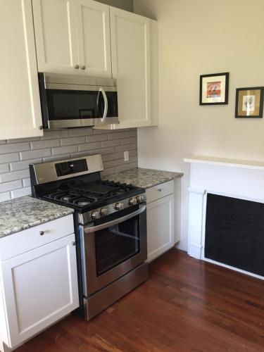 a kitchen with a stove and a microwave at Crescent City Cottage in New Orleans