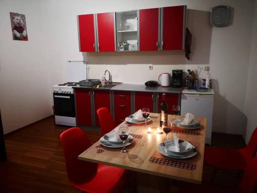uma cozinha com armários vermelhos e uma mesa de madeira com cadeiras vermelhas em Gacka-Beautiful Place in Nature em Otočac