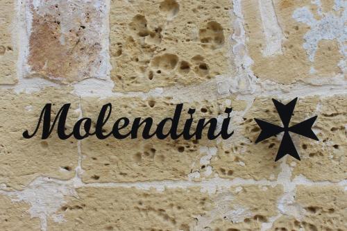 Un cartello su un muro di mattoni con la parola malilli di Molendini a Għarb