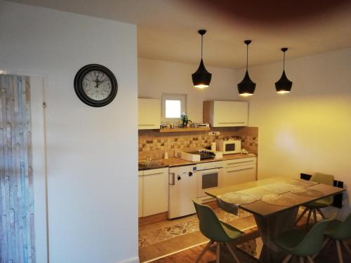 a kitchen with a table and a clock on the wall at House at Lake in Esztergom