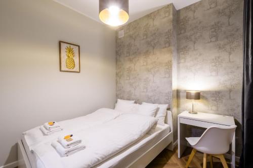 ワルシャワにあるApartament Centrum Kruczaのベッドルーム1室(白いベッド1台、デスク、椅子付)
