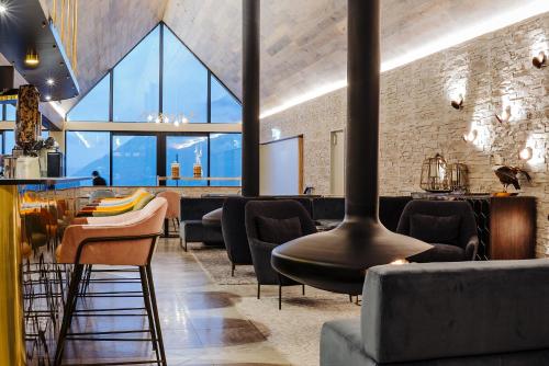 a restaurant with black chairs and tables and windows at Kamana Lakehouse in Queenstown