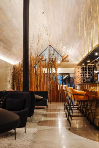 a restaurant with a bar with chairs and tables at Kamana Lakehouse in Queenstown