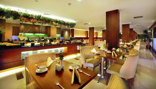 タンジュン・ピナンにあるASTON Tanjung Pinang Hotel & Conference Centerのテーブルと椅子のあるレストラン、バー