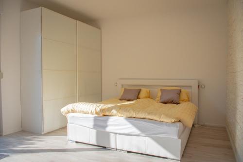 ein Schlafzimmer mit einem weißen Bett mit gelber Bettwäsche in der Unterkunft Liebesvolles Studio in Eppstein in Eppstein