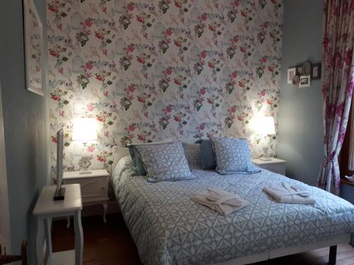 a bedroom with a bed with a floral wallpaper at Le Manoir de la mantille in Caudry