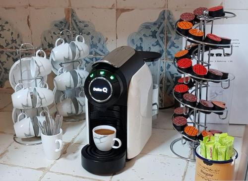 a coffee maker sitting on a counter next to cupcakes at Faro Town House in Faro