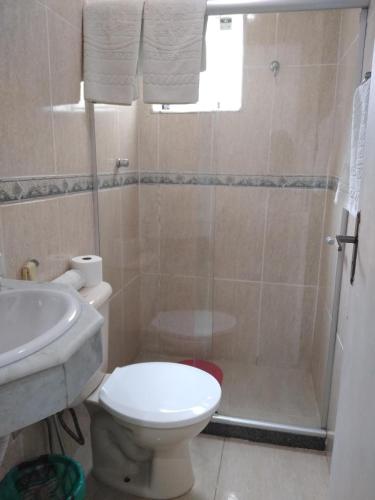 a bathroom with a shower and a toilet and a sink at Hotel Pousada Laje de Itauna in Saquarema