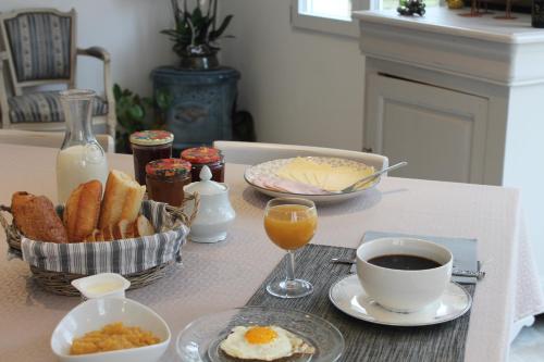 une table de petit-déjeuner avec des œufs, du pain grillé et une tasse de café dans l'établissement Domaine La Garence, à Villers-sous-Châtillon