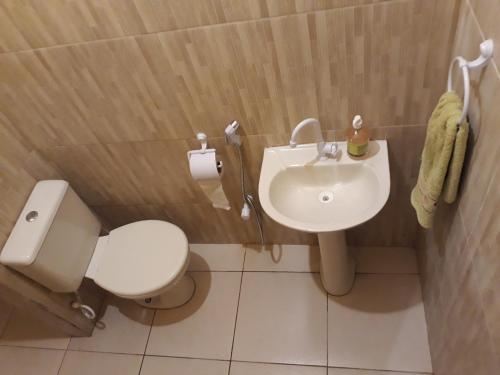 a bathroom with a white toilet and a sink at Do Alto da Montanha Pousada in Vale do Capao