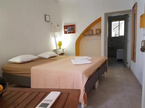 um quarto com duas camas e uma mesa num quarto em Faro Town House em Faro