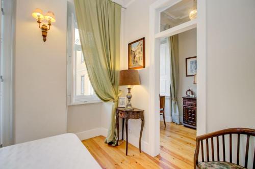 Cette chambre comprend un lit, une table et une fenêtre. dans l'établissement Graça Terrace, à Lisbonne